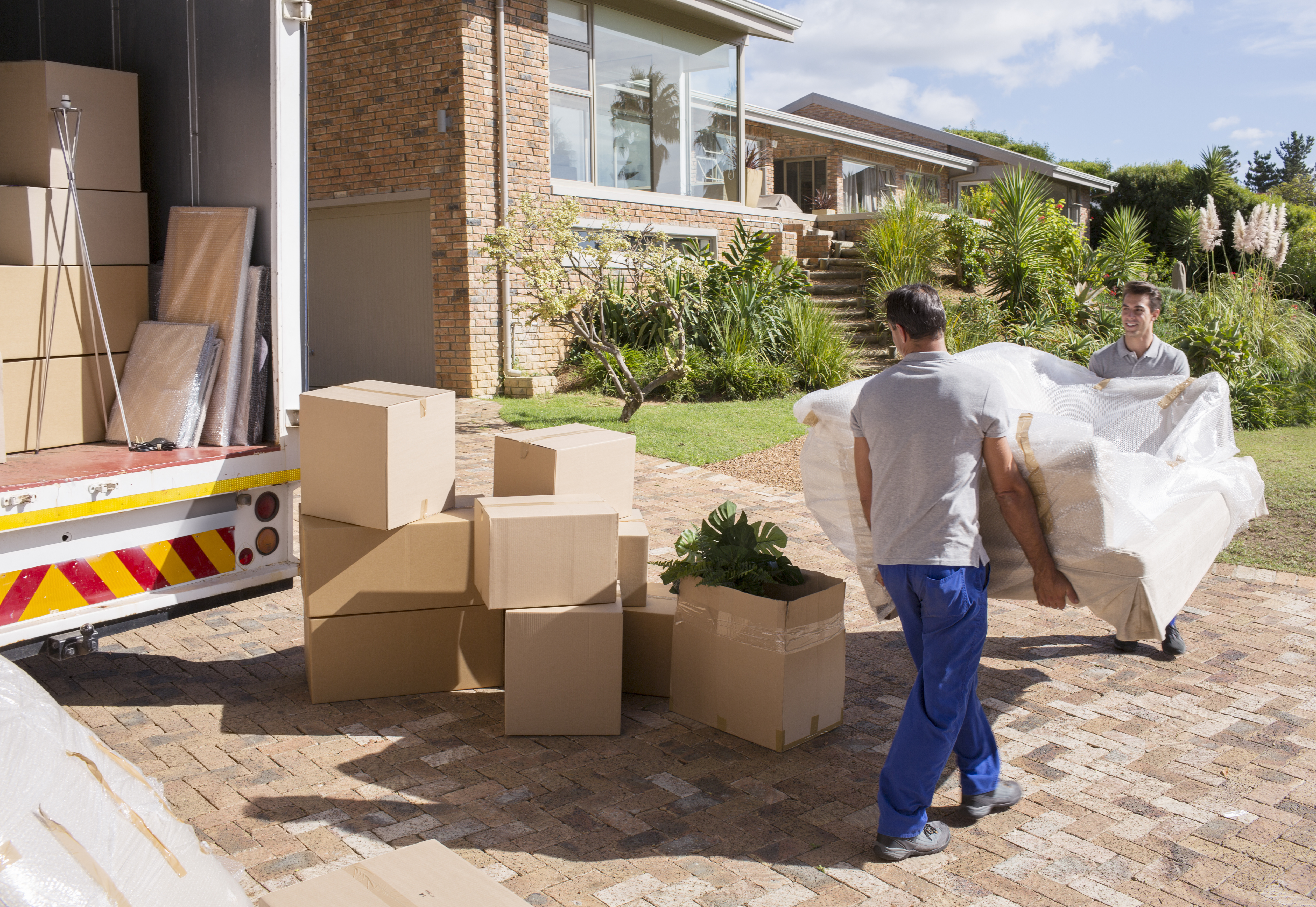 Network Moving professional movers carefully loading furniture and boxes into a moving truck for a residential relocation